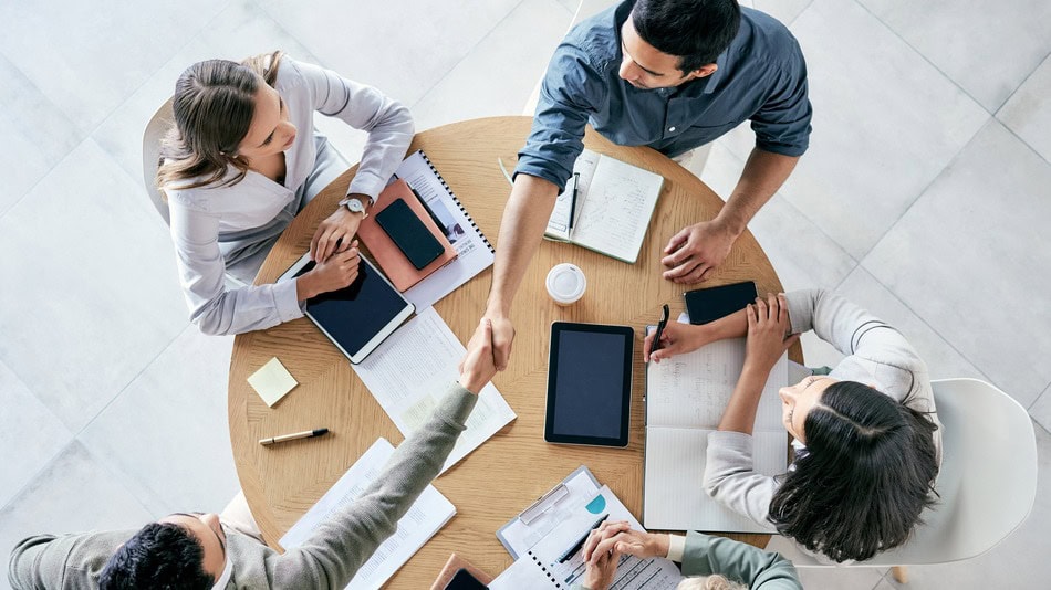 Equipo de trabajo reunido con móviles, tablets y portátiles